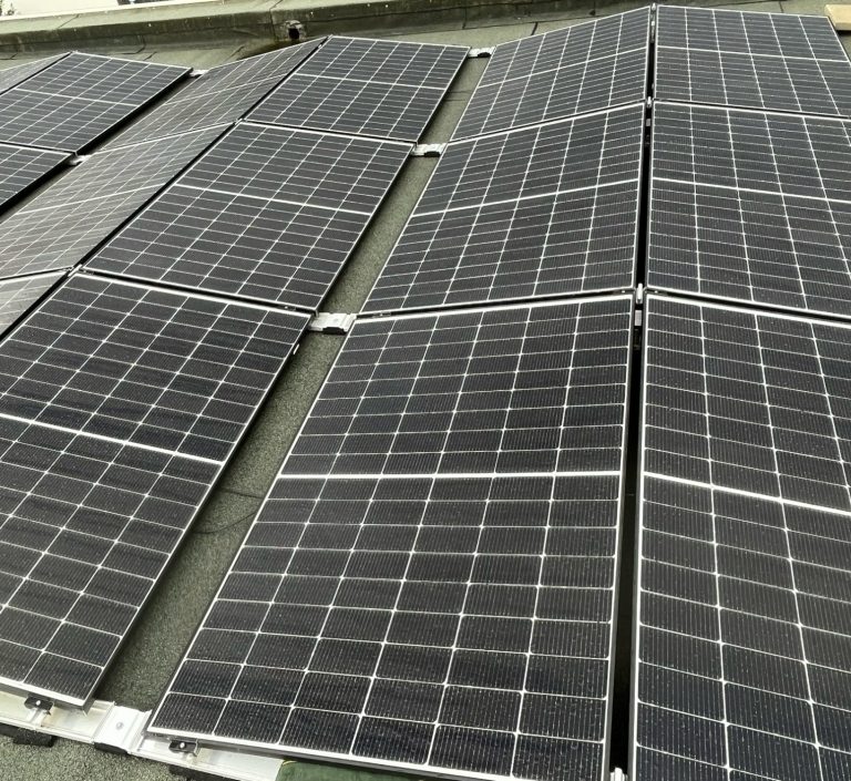 PV-Anlage auf Flachdach Dach mit mehreren Solarmodulen in einem geraden Muster. Flachdachmontage.